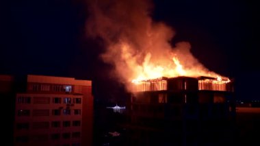 Yavaş hareket eden yangın, geceleri apartmanın çatısını tahrip ediyor.