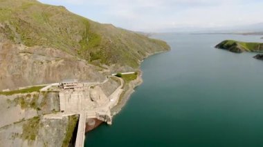 Hidroelektrik santralin havadan görünüşü. Rezervuardan dökülen suyla baraj