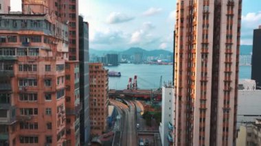 13 Mayıs 2024 - Hong Kong, Çin: Eski ve yeni binaların karışımının yer aldığı şehir manzarası, arka planda liman ve dağlar görülebiliyor, çeşitli şehirler yaratıyor.