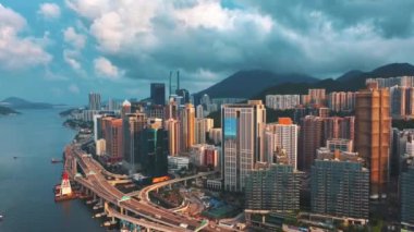 13 Mayıs 2024 - Hong Kong, Çin: Yüksek binaların ve işlek otoyolların yer aldığı, arka planda dağlar ve liman bulunan Hong Kong kıyı şeridinin havadan görünüşü dinamik bir şehir manzarası yaratıyor.