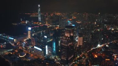 13 Mayıs 2024 - Hong Kong, Çin: Geceleyin Hong Kong limanının havadan görünüşü, aydınlatılmış gökdelenler ve şehrin ışıkları suya yansıyor, hareketli şehir manzarasını gözler önüne seriyor