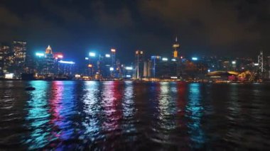 13 Mayıs 2024 - Hong Kong, Çin: Limanın karşısından Hong Kong 'un ufuk çizgisinin gece görüşü, aydınlık gökdelenler ve canlı şehir ışıkları suya yansıyor, çarpıcı bir şehir manzarası yaratıyor.