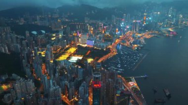 13 Mayıs 2024 - Hong Kong, Çin: Geceleri Hong Kong limanı ve şehir manzarasının hava manzarası aydınlık binalar, hareketli şehir ışıkları ve liman boyunca hareketli bir şehir manzarası sergilenmektedir.