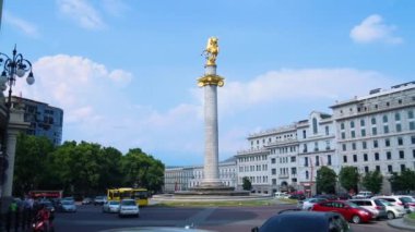 Tiflis, Gürcistan - 13 Temmuz 2018: Tiflis Özgürlük Meydanı. Meydanın ortasında bir heykeli olan şehir yollarda, arabalarda ve tarihi merkezde evleri olan bir yer..