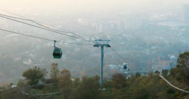 Almaty Kazakistan 'daki Kok-tobe tepesine giden kablo yol sisli bir gün.