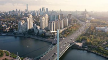 Astana şehri Kazakistan 'ın Ishim nehri üzerindeki Karaotkel köprüsü ve arka planında bayrak sallayan havadan görüntüsü.