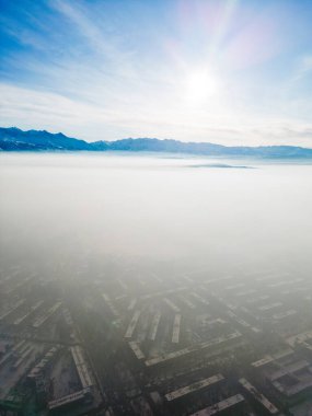 Kış boyunca sisle kaplı fosil yakıtlardan kirlenmiş şehrin havadan görünüşü