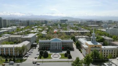 Bishkek, Kırgızistan - 13 Mayıs 2023: Arka planda karlı dağlar bulunan Bişkek Belediye Binası 'nın havadan görünüşü