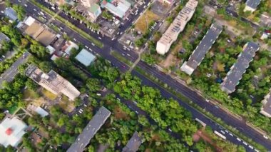 Bişkek, Kırgızistan 'ın hava manzarası, şehir binalarının karışımı, yemyeşil ve arabalarla dolu yoğun bir ana yol.