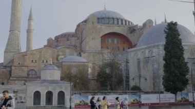 İstanbul, Türkiye - 21 Ekim 2022: Ayasofya 'nın tarihi cephesi ve ön plandaki ziyaretçileriyle gündüz görünümü