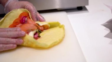 Somon, krem peynir, bebek roka ve taze domatesli Tapioca unu pişirmenin yavaş çekim görüntüsü.