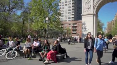 New York, ABD - 15 Nisan 2019: İnsanlar Greenwich Village 'daki Washington Square Park' ta bir gün boyunca yürüyorlar