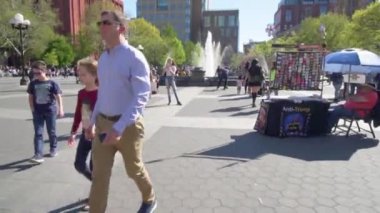 New York, ABD - 15 Nisan 2019: İnsanlar Greenwich Village 'daki Washington Square Park' ta bir gün boyunca yürüyorlar