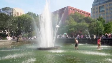 New York, ABD - 15 Nisan 2019: Washington Square Park çeşmesinde yüzen yavaş çekim çocukları