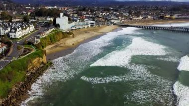 Santa Cruz sahil kaldırım eğlence parkının hava manzarası. Sahilde sörf yapan insanlarla.