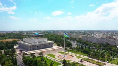 Taşkent, Özbekistan - 13 Haziran 2024: Özbekistan bayrağı önde dalgalanırken Taşkent 'teki Uluslar Sarayı Dostluğu' nun Havadan görünüşü