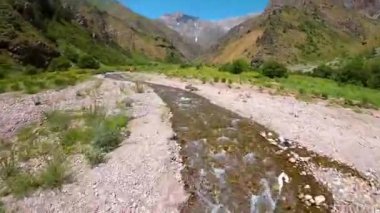 Güneşli bir günde Özbekistan 'daki yeşim taşı Urungach Gölü' nü dolduran nehrin birinci şahıs görüntüsü