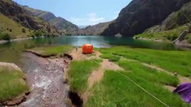 Taşkent, Özbekistan - 15 Mayıs 2024: Güneşli bir günde Özbekistan 'da kamp yapan turistlerle birlikte Urungach Gölü' nün birinci şahıs görüntüsü