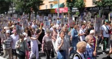 Bishkek, Kırgızistan - 9 Mayıs 2022: 9 Mayıs Zafer Günü ölümsüz alay. İnsanlar büyük vatanseverlik savaşına katılan akrabalarının afiş resimleriyle köşe yazıları yazıyorlar.