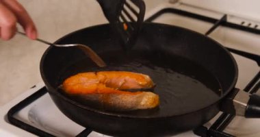 Somon balığının her tarafını sıcak tavada kızartmak ve ev mutfağında kızgın yağla kızartmak.