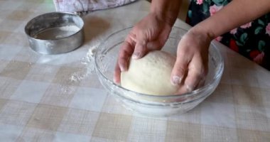 Mangırı kaseye koyan kadının yakın çekimi.