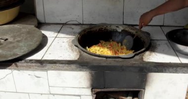 Pirinç yemeği hazırlamak için kazanda dilimlenmiş havuç kızartıyorlar.