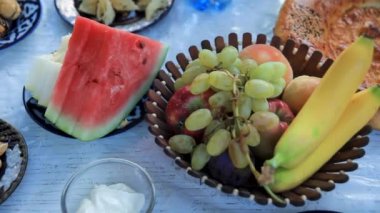 Taze meyve kasesi ekmek ve hamur işi ile servis edilen masa manzarası