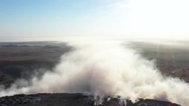Çöp sahasında yanan çöplerden çıkan hava manzarası, Dünya kirliliği kavramı.