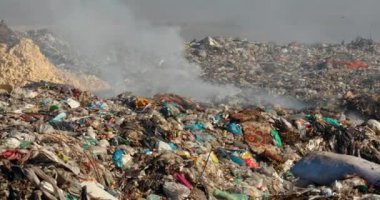 Arazi sahasında uçan kargalarla dolu çöp yığınlarının yakılması