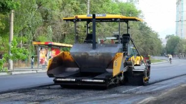 Bişkek, Kırgızistan - 14 Ağustos 2024: Bir şehir caddesinde yol yapımı sırasında faaliyet gösteren bir Volvo P7820D ABG asfalt kaldırım geçidi, ekipmanın altyapı geliştirmedeki rolünü vurguluyor