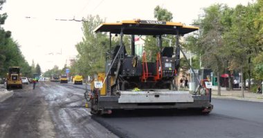 Bişkek, Kırgızistan - 14 Ağustos 2024: Bir şehir caddesinde yol yapımı sırasında faaliyet gösteren bir Volvo P7820D ABG asfalt kaldırım geçidi, ekipmanın altyapı geliştirmedeki rolünü vurguluyor