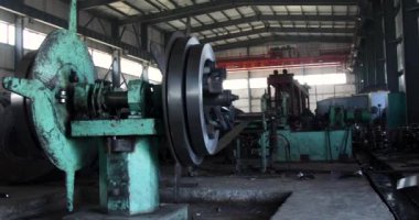 Fabrikada metal borular ve borular üretmek için kullanılan soğuk rulo çelik bobinleri açan makine.