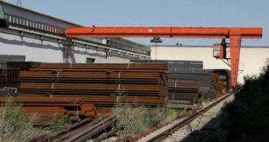 Gantry vinci çelik fabrikasında metal borular taşıyor.