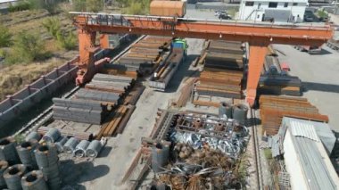 Metal borulara gantry vinç yükleyen işçilerin hava görüntüsü