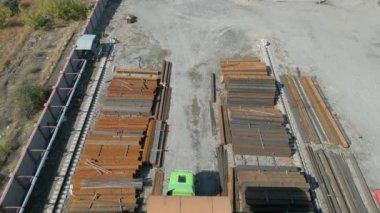 Metal borulara gantry vinç yükleyen işçilerin hava görüntüsü
