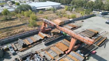 Metal borulara gantry vinç yükleyen işçilerin hava görüntüsü