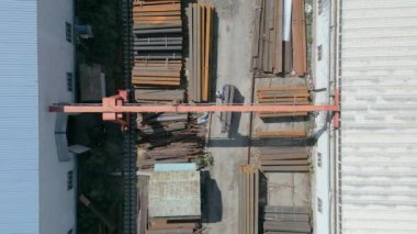 Metal boruları gantry vinçle yükleyen işçilerin havadan aşağı görüntüsü