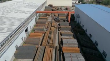 Galvanize demir boruların hava görüntüsü ve arka planda gantry vinç ile paslanmaz çelik dikdörtgen metal çubuklar