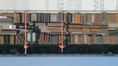 Metal boruları gantry vinçle yükleyen işçilerin havadan aşağı görüntüsü