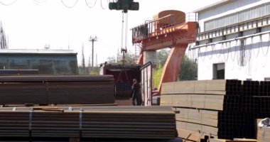 İşçiler metal borulara gantry vinç yüklüyorlar