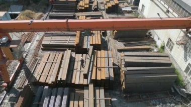 Çelik fabrikasında metal borular taşıyan işçilerin hava görüntüsü.