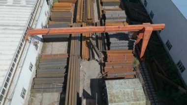 Çelik fabrikasında metal borular taşıyan işçilerin hava görüntüsü.