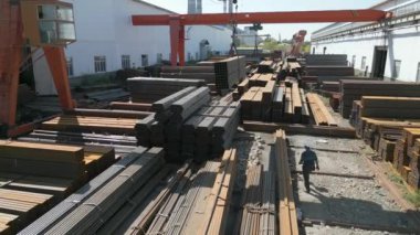 Çelik fabrikasında metal borular taşıyan işçilerin hava görüntüsü.