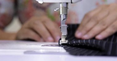 Elektrikli dikiş makinesinde çalışan terzinin kapağı