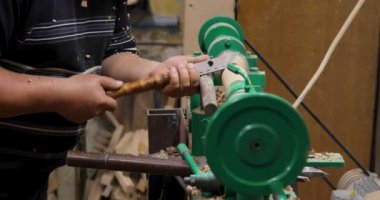 Marangozun torna tezgahına ahürat yapması. Torna tezgahına keski şamdanı oyan kişi