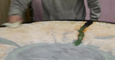 Marangoz ahşap epoksi masasını keten tohumu yağıyla kaplıyor. Ahşap masa yapma süreci