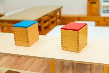 Birinde kırmızı, diğerinde mavi kapaklı iki Montessori küp kutusunun detaylı görüntüsü