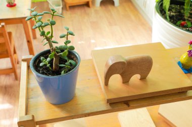 Wooden Montessori shelves displaying various objects and decorations, enhancing the classroom environment for early childhood education clipart