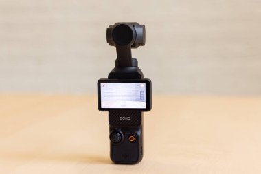 Bishkek, Kırgızistan - 4 Kasım 2024: DJI Osmo Pocket 3 ön görünüm tahta yüzey üzerinde arayüzü gösteren ekran