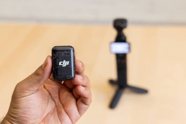 Bishkek, Kırgızistan - 4 Kasım 2024: Ön camlı DJI Mic 2 vericisi, arka planda Osmo Pocket 3 kamerası bulanık